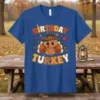 Birthday Turkey T-Shirt featuring a cute cartoon turkey wearing a pilgrim hat, surrounded by fall leaves and acorns
