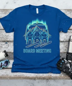 Blue t-shirt with "Board Meeting" text and graphic of three skiers on a ski lift, vibrant green aurora borealis in