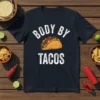Dark navy t-shirt with white text "BODY BY TACOS" and a graphic of a taco in the center