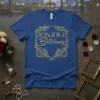 Bonjour Bitches text in gold glitter font with floral border on a royal blue t-shirt
