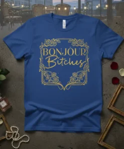 Bonjour Bitches text in gold glitter font with floral border on a royal blue t-shirt