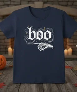 Navy blue t-shirt with white gothic font spelling "boo" and a skeleton hand pointing left, surrounded by wisps and stars