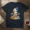 Ghost reading books with "BOOOOKS" text and scattered books, Halloween theme, on a dark t-shirt