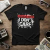 Black t-shirt with "BREAKING NEWS I DON'T CARE" in bold white and red distressed typography