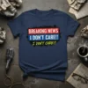 T-shirt with "BREAKING NEWS I DON'T CARE!! I DON'T CARE!!" text in bold red, white, blue, and yellow fonts on