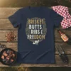 Brisket Butts Ribs & Freedom text design on a navy t-shirt with vintage distressed gold and white lettering and a