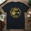 Buen Camino 2025 text with a golden scallop shell and arrow emblem on a black t-shirt