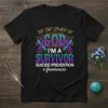 T-shirt with "By The Grace Of God I'm A Survivor Suicide Prevention Awareness" text and teal/purple ribbons