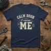 Navy t-shirt with "Calm Doon it Wasnae Me" in distressed cream lettering, featuring wrench and spark graphics