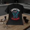 Cappuccino Assassino text design with a cartoon ninja coffee cup holding swords on a black t-shirt