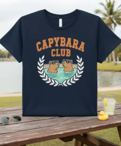Capybara Club t-shirt design featuring two capybaras wearing sunglasses in a pool, surrounded by a laurel wreath
