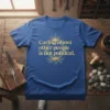 T-shirt with the quote "Caring about other people is not political" in golden yellow typography with a tree root graphic