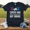 CHEER DAD Like a Regular Dad BUT BROKE text with cheerleaders and megaphone graphic on a navy t-shirt