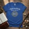 Blue t-shirt with white text quote "...Choose you this day whom ye will serve.." and ornate golden emblem with "JOSHUA