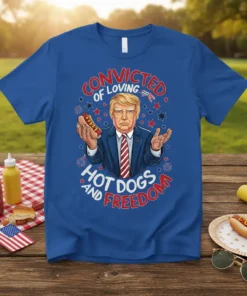 Trump holding a hot dog with text "Convicted of Loving Hot Dogs and Freedom" on a blue t-shirt