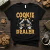 Black t-shirt with "Cookie Dealer" text in distressed yellow font and a character holding cookie trays