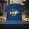 Cool Uncles Club text graphic on a blue t-shirt, featuring retro typography and star accents