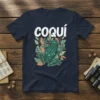 Coqui frog illustration with the word "coquí" above it, surrounded by tropical leaves on a navy blue t-shirt