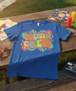 Retro graphic t-shirt with the words "Cousin Crew" in bold, colorful, wavy font surrounded by groovy floral and swirl designs