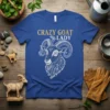Crazy Goat Lady text in gold glitter font above a detailed illustration of a goat's head on a blue t-shirt