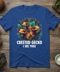 Crested Gecko I See You! text on a royal blue t-shirt with three orange crested geckos and green leaves graphic
