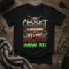 T-shirt design featuring the text "Crochet Is Not a Hobby It's A Post Apocalyptic Survival Skill" with crochet hooks and