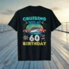 Cruising Into My 60th Birthday text with cruise ship, palm trees, and balloons graphic on a black t-shirt