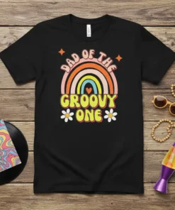 Dad of the Groovy One text with retro rainbow and stars on a black t-shirt