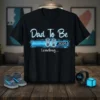 Dad To Be 2026 Loading... text and graphic on a black t-shirt, featuring baby shoes and a progress bar