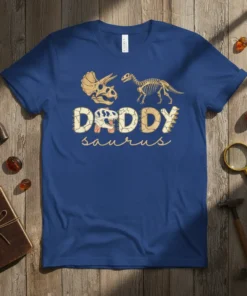 Daddy Saurus text with dinosaur skull and skeleton graphics on a navy blue t-shirt, perfect for a dad dinosaur gift