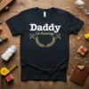 Daddy in training quote with hammer and wrench graphics on a black t-shirt, ideal for new dads