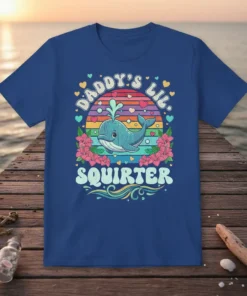 Daddy's Lil Squirter text with a cute cartoon whale graphic, rainbow background, and floral accents on a blue t-shirt