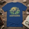 Daddysaurus text with T-Rex and baby dinosaur graphic on a blue t-shirt, prehistoric jungle theme