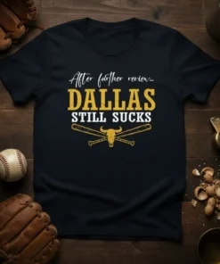 Black t-shirt with white and gold text "After further review... DALLAS STILL SUCKS" and a bull skull with crossed baseball