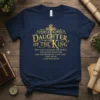 Navy t-shirt with gold lettering: Daughter of the King verse 2 Corinthians 6:18, featuring ornate cross graphic
