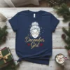 December Girl t-shirt design with gold glitter text and a woman's face graphic, adorned with snowflakes