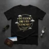 Do I Look Like I Fly Economy? text with airplane graphic on a black t-shirt, featuring clouds and glitter accents