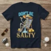 Don't Be Salty t-shirt design with a skeleton relaxing on a beach chair holding a drink