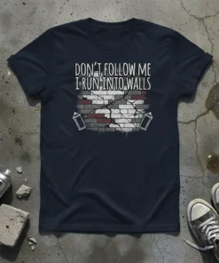 "Don't Follow Me I Run Into Walls" quote on a dark t-shirt with a cracked brick wall graphic and spray