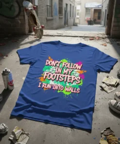 Blue t-shirt with "Don't Follow In My Footsteps I Run Into Walls" in bold, colorful graffiti-style text