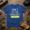 Blue t-shirt with "DON'T LET THE HARD DAYS WIN" text in distressed white and yellow design