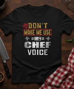 Black t-shirt with "Don't Make Me Use My Chef Voice" text in distressed yellow, red, and white typography, featuring a