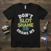 Don't Slot Shame Shame Me humorous quote on a black t-shirt, featuring slot machine graphics and bright colors