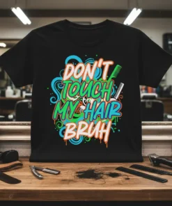 Black t-shirt with "DON'T TOUCH MY HAIR BRUH" text in colorful graffiti style, featuring scissors and comb graphics