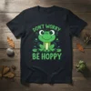 Don't Worry Be Hoppy text with a cute cartoon frog sitting on lily pads, green and white design