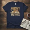 Doodles And Books t-shirt featuring a doodle dog laying on an open book with stacked books beside it