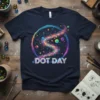 Navy t-shirt with "Dot Day" text and a swirling rainbow graphic filled with colorful dots and bubbles