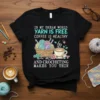 Black t-shirt with "In My Dream World Yarn Free Coffee Healthy And Crocheting Makes You Thin" quote, yarn basket, and