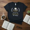 Drink Tea, Read Books, Be Happy quote on a dark t-shirt, featuring a stack of books and a cup of