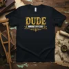 Black t-shirt with yellow distressed text "DUDE WHERE'S MY LEG?" and decorative banner, featuring a humorous recovery theme